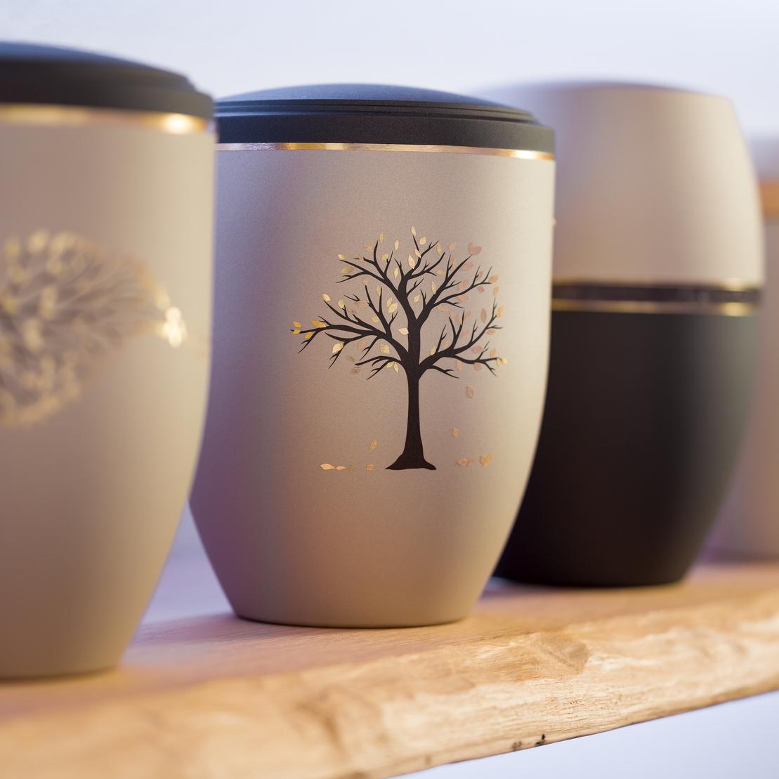 Reihe dekorativer Urnen mit bunten Motiven aus Blättern und Bäumen auf einem Holzregal.