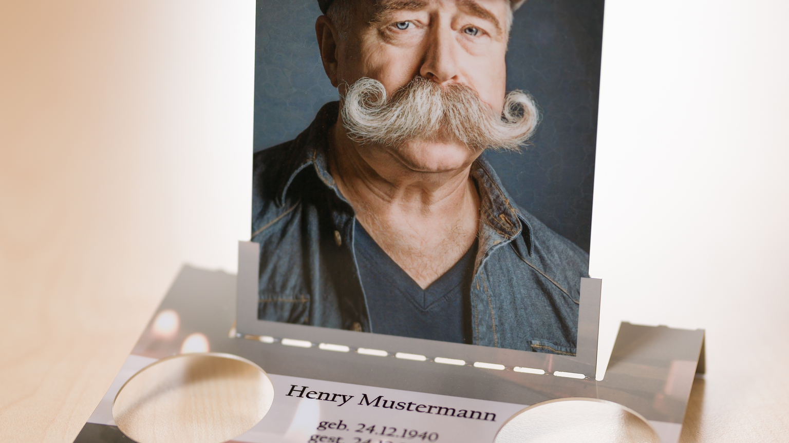 Porträt eines Mannes mit Schnurrbart und Mütze, auf einem Rahmen mit persönlichen Daten unten.